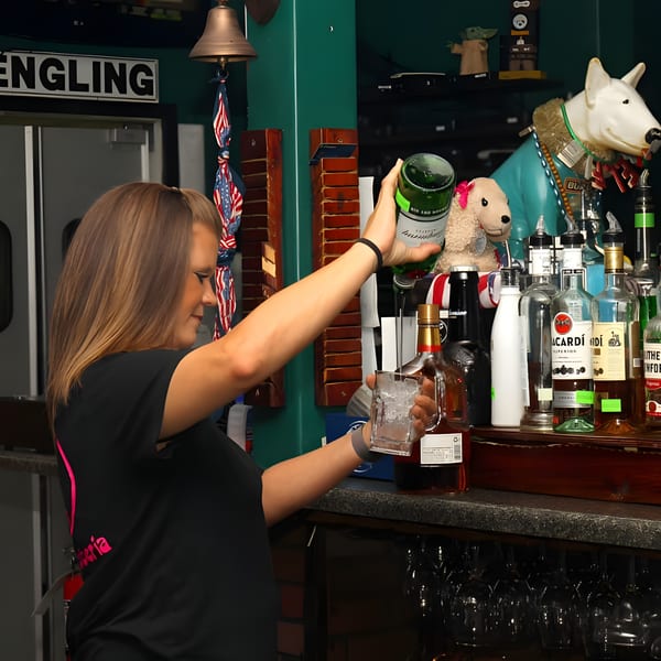 Bartender pouring a drink into a glass filled with ice at Big Al's Pub & Grubberia.